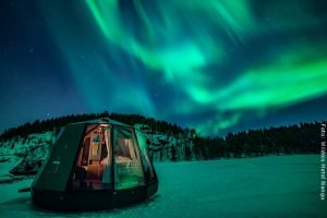Nordlichterhütte mit Nordlichtern auf zugefrorenem Inarisee in Nangu Lappland