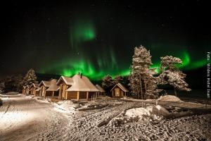 Nordlichter Hütten mit Nordlichtern im Winter im Wildnishotel Inari Lappland