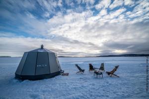 Camping vor Nordlichterhütte auf zugefrorenem Inarisee im Wildnishotel Nangu Lappland